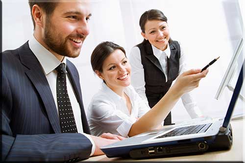 Three people sitting in front of a computer discussing something on its screen